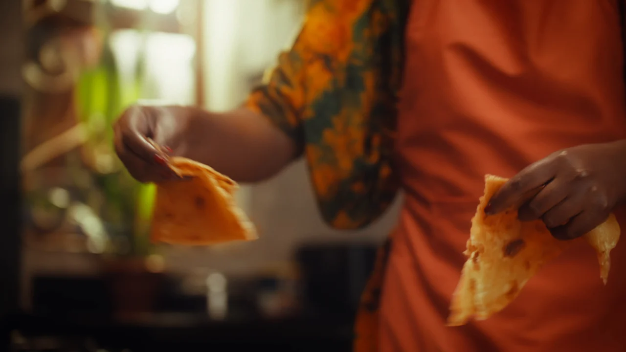 Warmly lit close-up of a woman preparing food